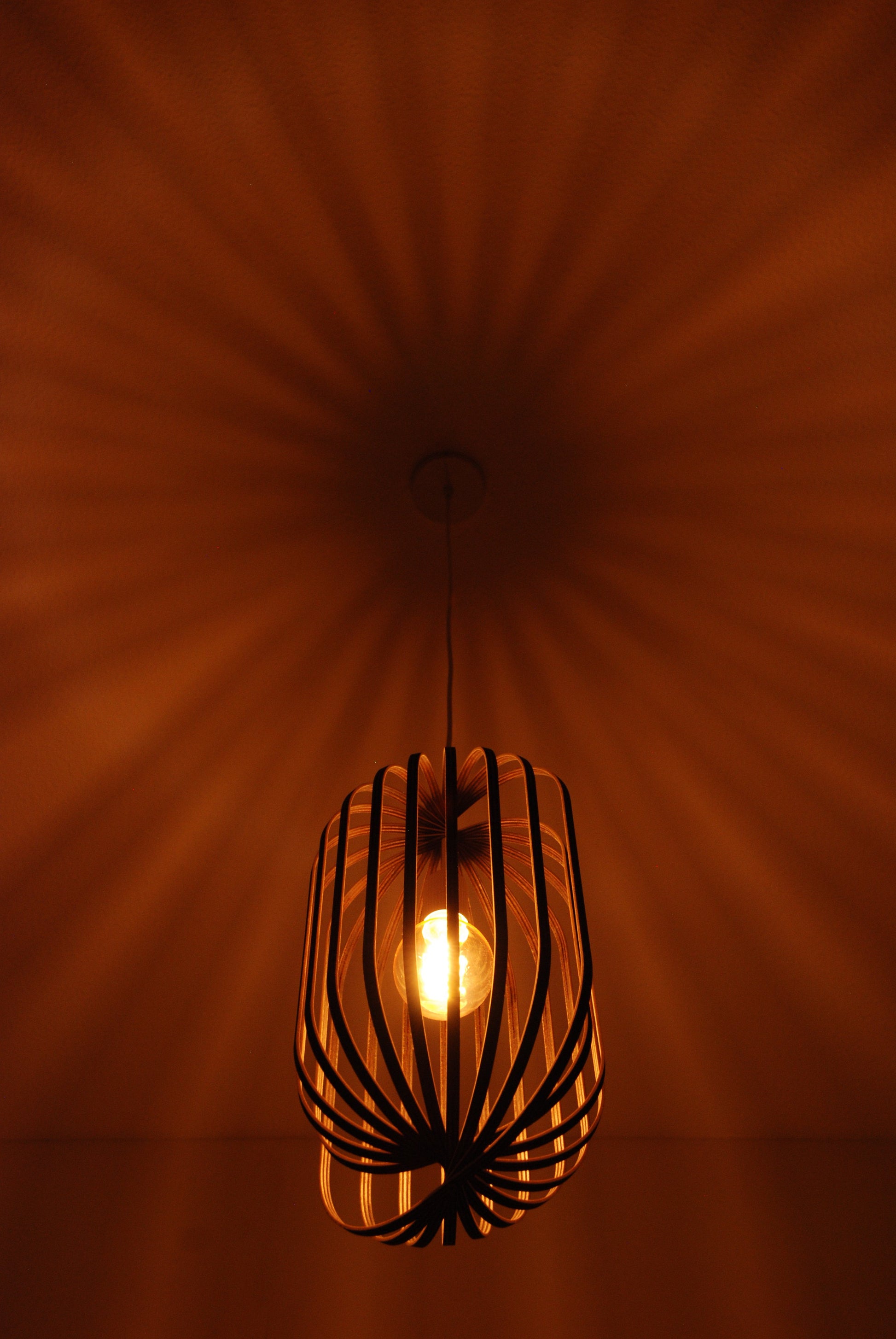 LUWALD NO.04 L Pendelleuchte aus Holz, weiß, handgefertigt, zylinderförmig, angeschaltet, Ringe, Atmosphäre, Hängelampe, Schatten an Decke, Deckenmontage, warm