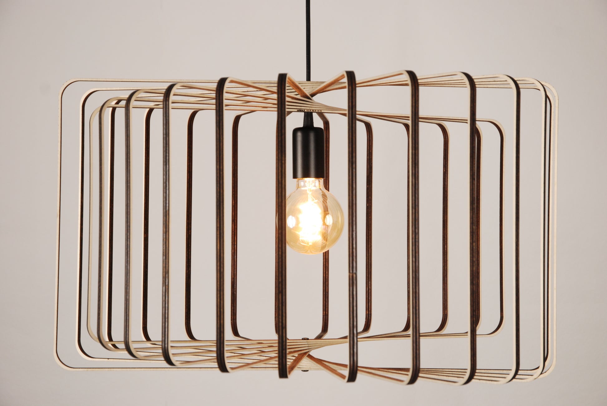 LUWALD NO.01 Pendelleuchte aus Holz, schwarz, handgefertigt, zylinderförmig, angeschaltet, Seitenansicht