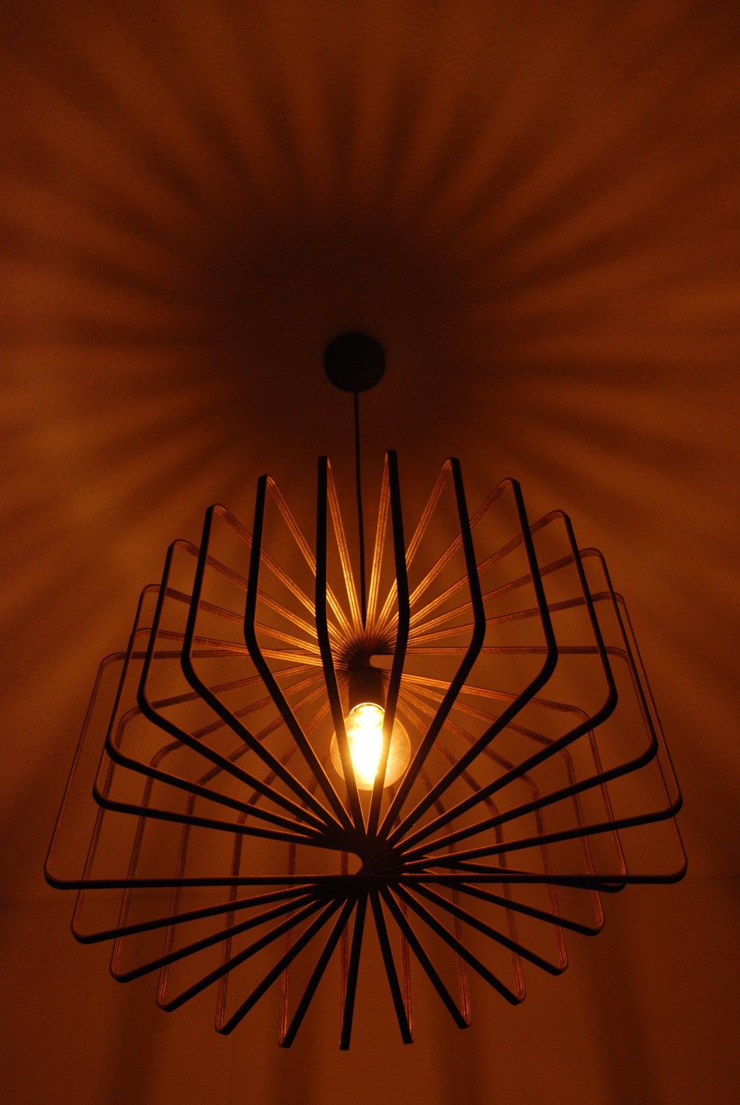 LUWALD NO.01 Pendelleuchte aus Holz, schwarz, handgefertigt, zylinderförmig, angeschaltet, Schatten an der Decke