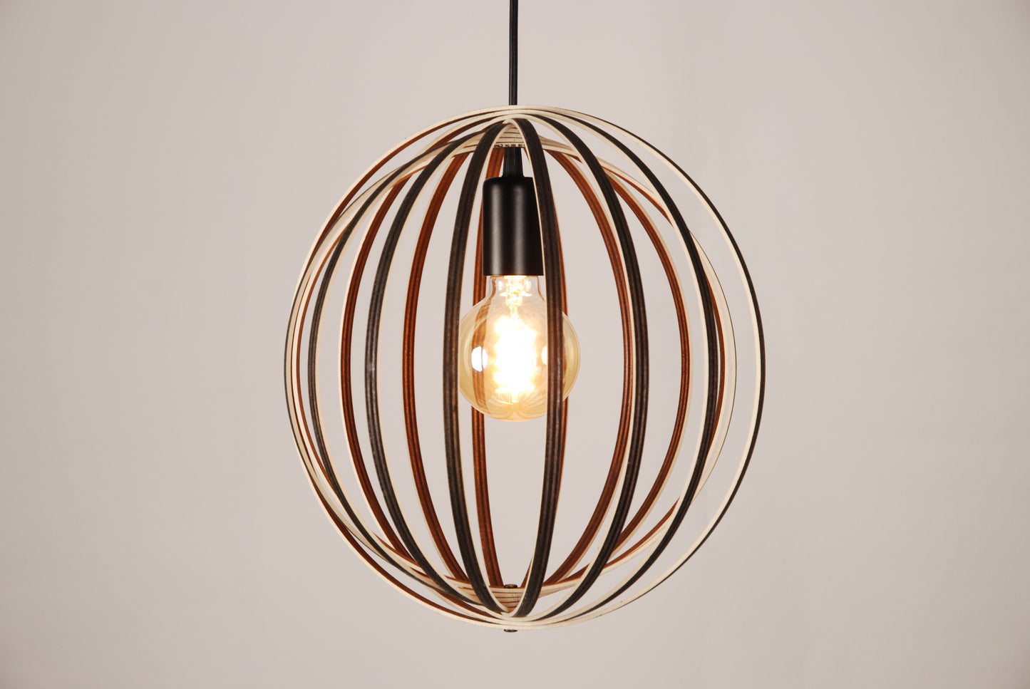 LUWALD NO.03 S Pendelleuchte aus Holz, schwarz, handgefertigt, kugelförmig, angeschaltet, Seitenansicht