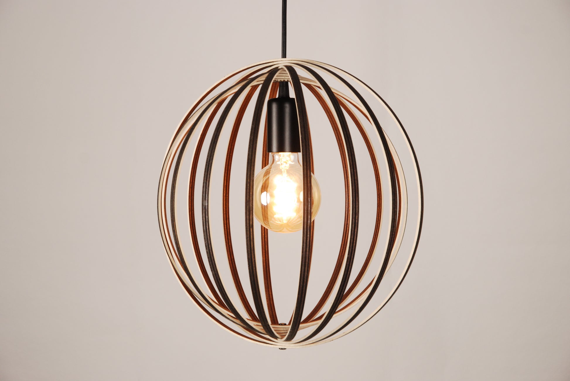 LUWALD NO.03 S Pendelleuchte aus Holz, schwarz, handgefertigt, kugelförmig, angeschaltet, Seitenansicht