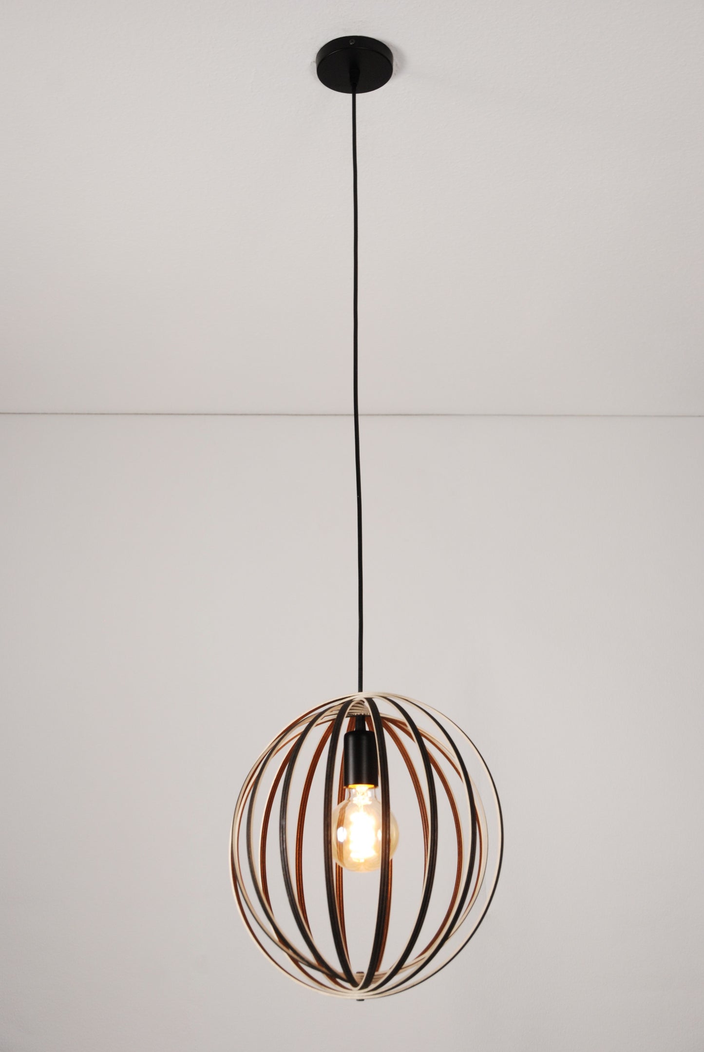 LUWALD NO.03 S Pendelleuchte aus Holz, schwarz, handgefertigt, kugelförmig, angeschaltet, Gesamtansicht