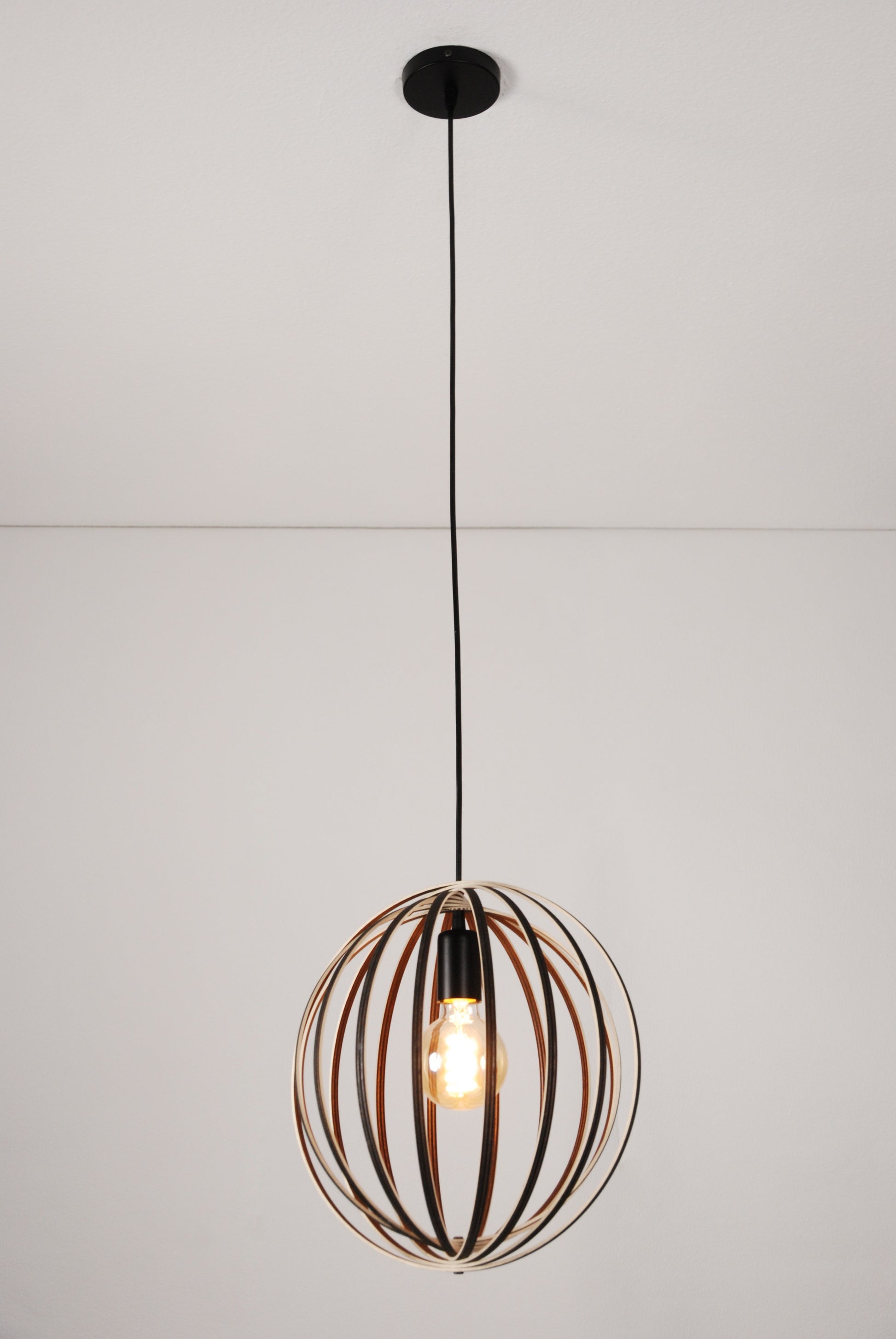 LUWALD NO.03 S Pendelleuchte aus Holz, schwarz, handgefertigt, kugelförmig, angeschaltet, Gesamtansicht