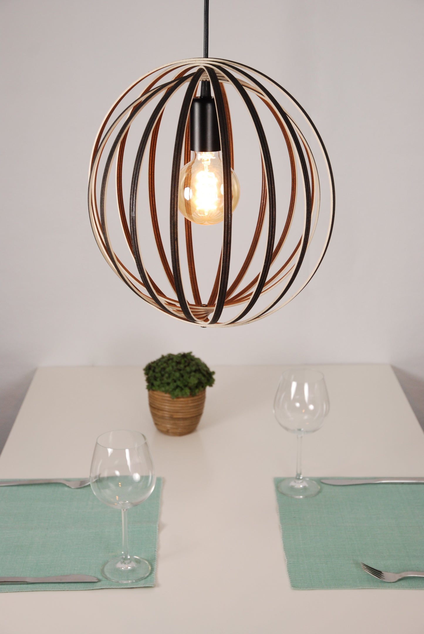 LUWALD NO.03 S Pendelleuchte aus Holz, schwarz, handgefertigt, kugelförmig, angeschaltet, Deko Tisch