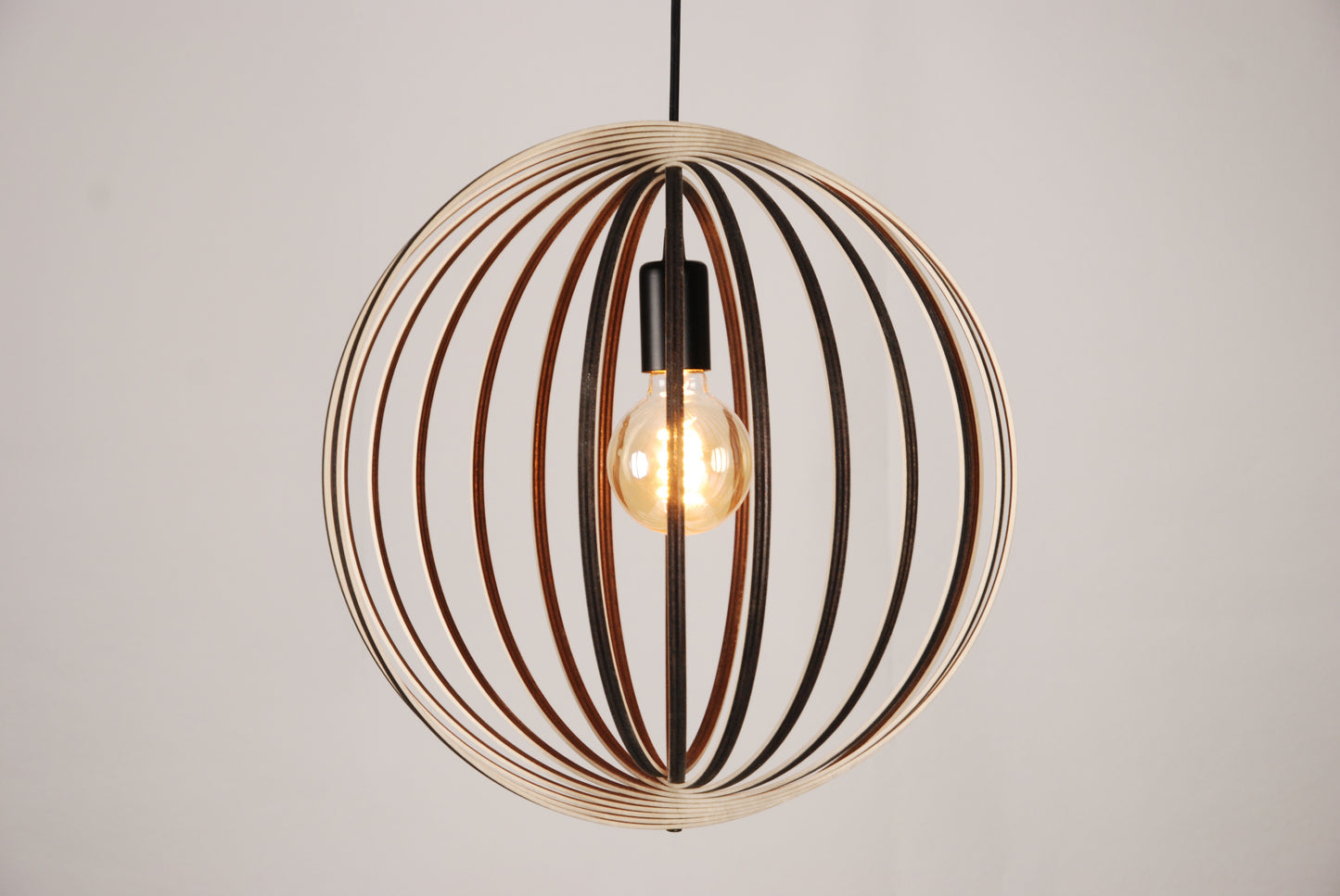 LUWALD NO.03 M Pendelleuchte aus Holz, schwarz, handgefertigt, kugelförmig, angeschaltet, Seitenansicht