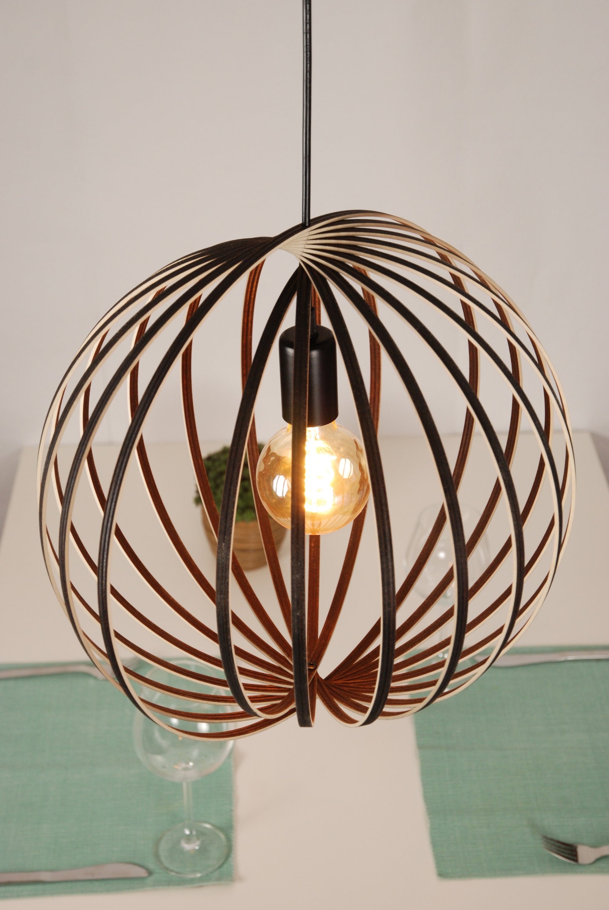 LUWALD NO.03 M Pendelleuchte aus Holz, schwarz, handgefertigt, kugelförmig, angeschaltet, schräg von oben