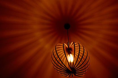 LUWALD NO.03 M Pendelleuchte aus Holz, schwarz, handgefertigt, kugelförmig, angeschaltet, Schatten an Decke