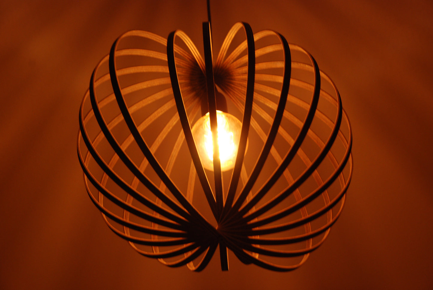 LUWALD NO.03 M Pendelleuchte aus Holz, schwarz, handgefertigt, kugelförmig, angeschaltet, Stimmung, schräg von unten