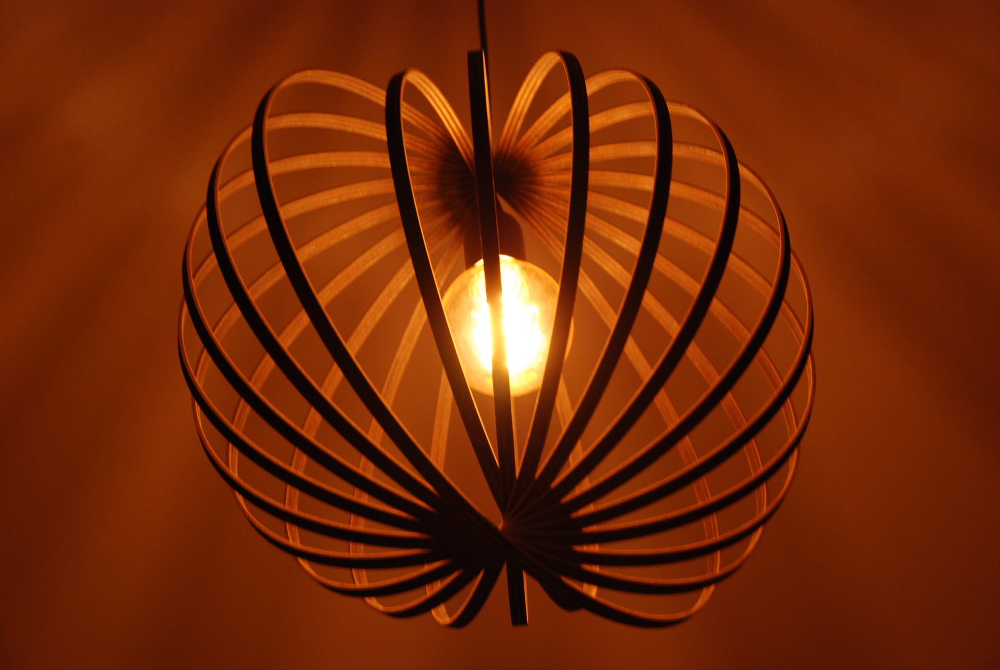 LUWALD NO.03 M Pendelleuchte aus Holz, schwarz, handgefertigt, kugelförmig, angeschaltet, Stimmung, schräg von unten