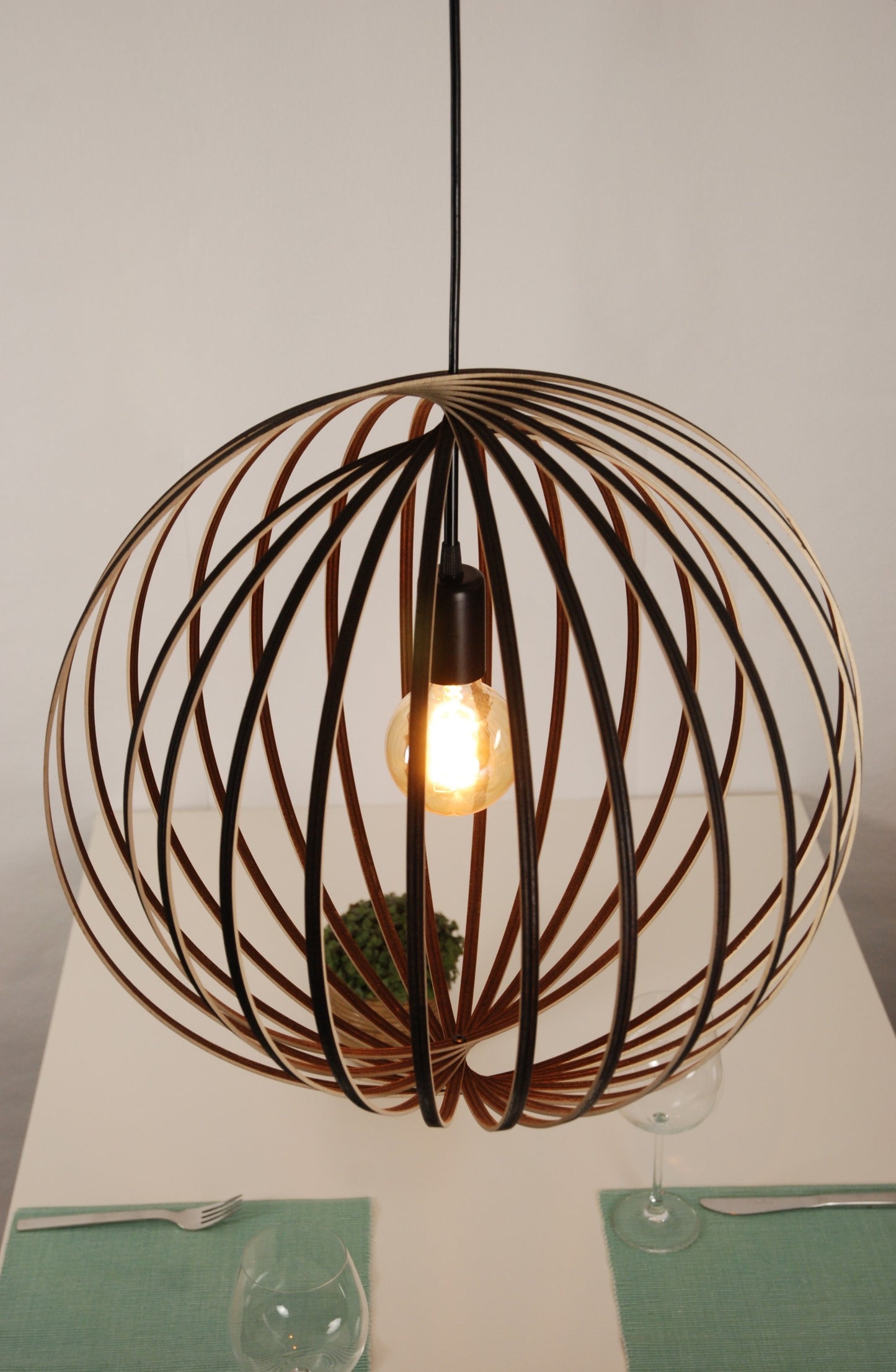 LUWALD NO.03 L Pendelleuchte aus Holz, schwarz, handgefertigt, kugelförmig, angeschaltet, von schräg oben