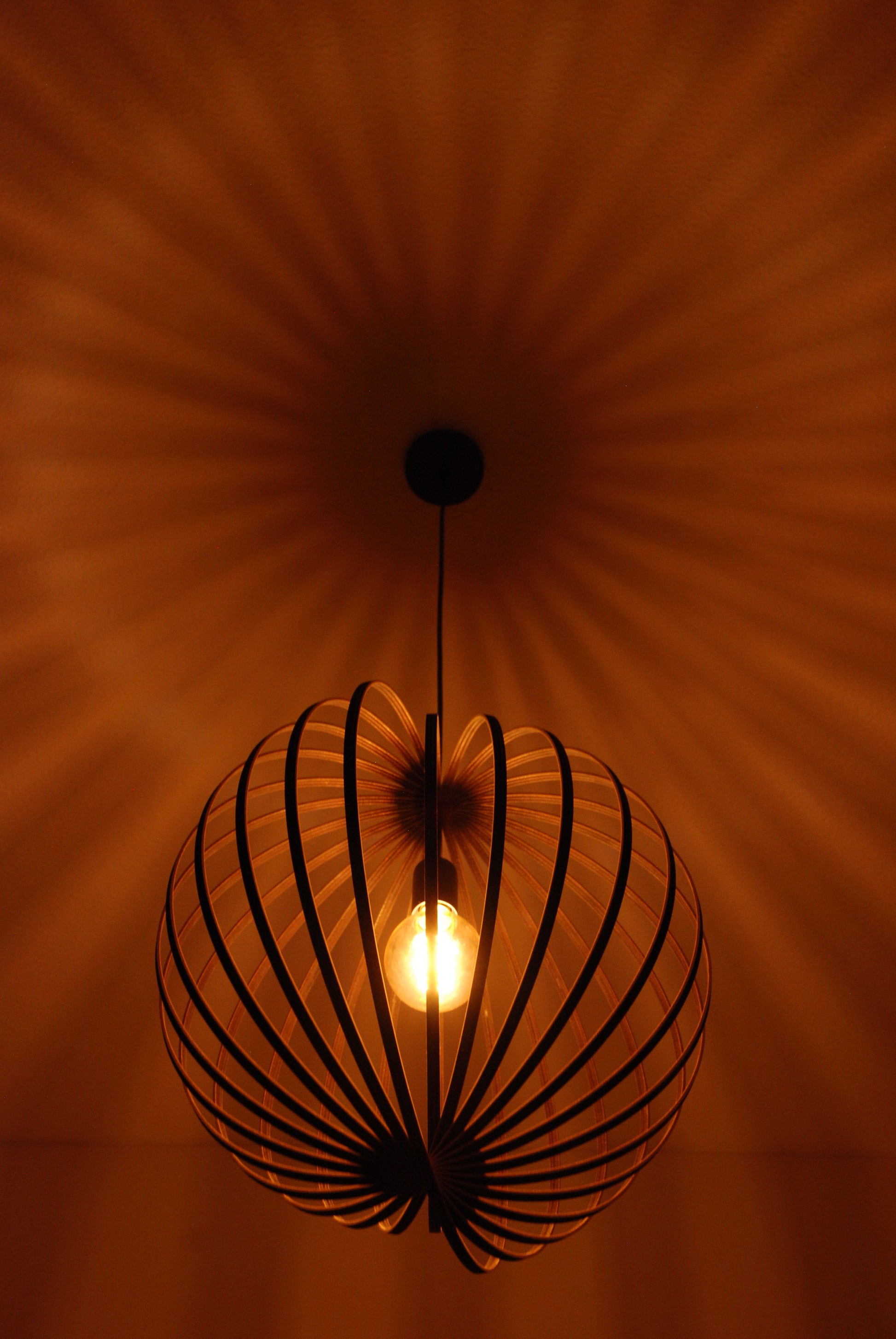 LUWALD NO.03 L Pendelleuchte aus Holz, schwarz, handgefertigt, kugelförmig, angeschaltet, Decke Schatten, gemütlich, warm, Atmosphäre