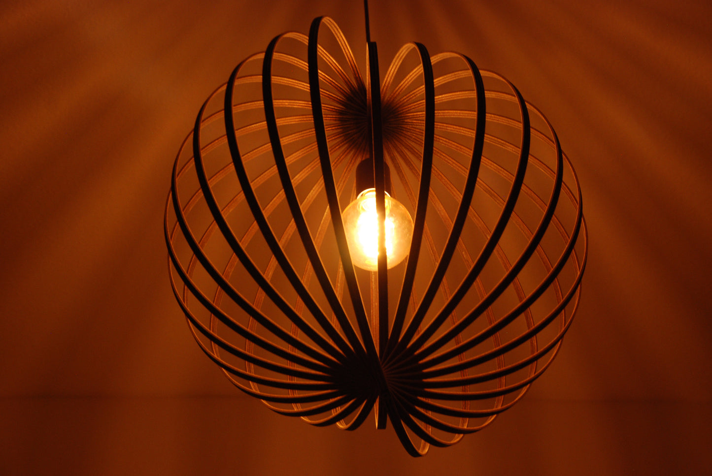 LUWALD NO.03 L Pendelleuchte aus Holz, schwarz, handgefertigt, kugelförmig, angeschaltet, Decke Schatten, warm