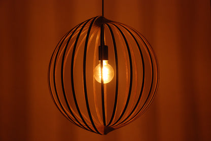 LUWALD NO.03 L Pendelleuchte aus Holz, schwarz, handgefertigt, kugelförmig, angeschaltet, Seitenansicht, warm