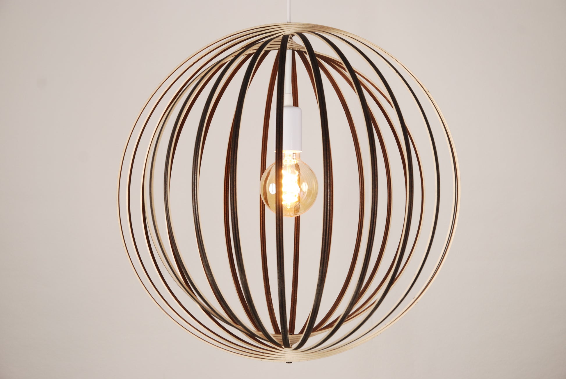 LUWALD NO.03 L Pendelleuchte aus Holz, weiß, handgefertigt, kugelförmig, angeschaltet, Seitenansicht