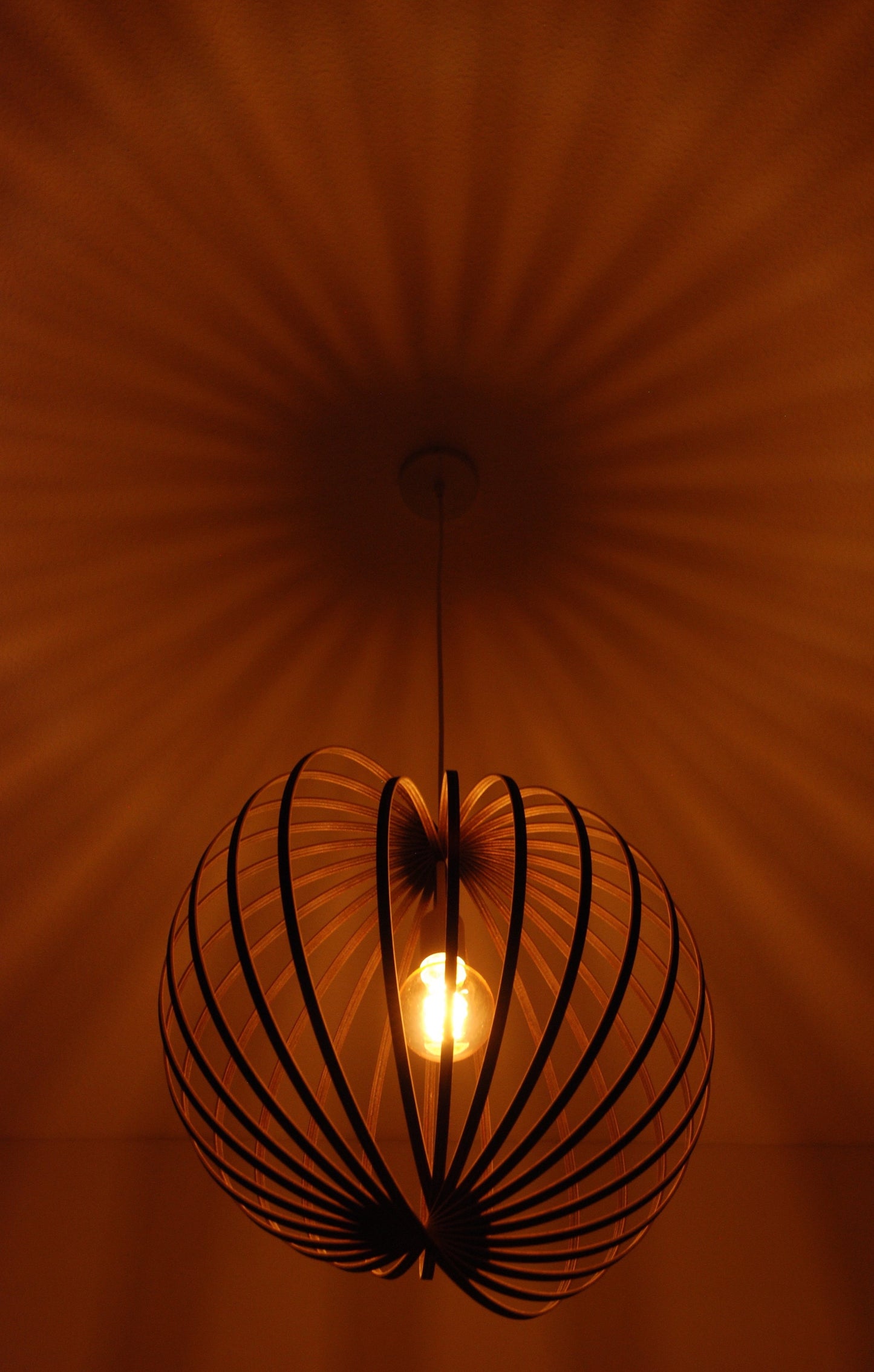 LUWALD NO.03 L Pendelleuchte aus Holz, weiß, handgefertigt, kugelförmig, angeschaltet, Schatten an Decke, warm