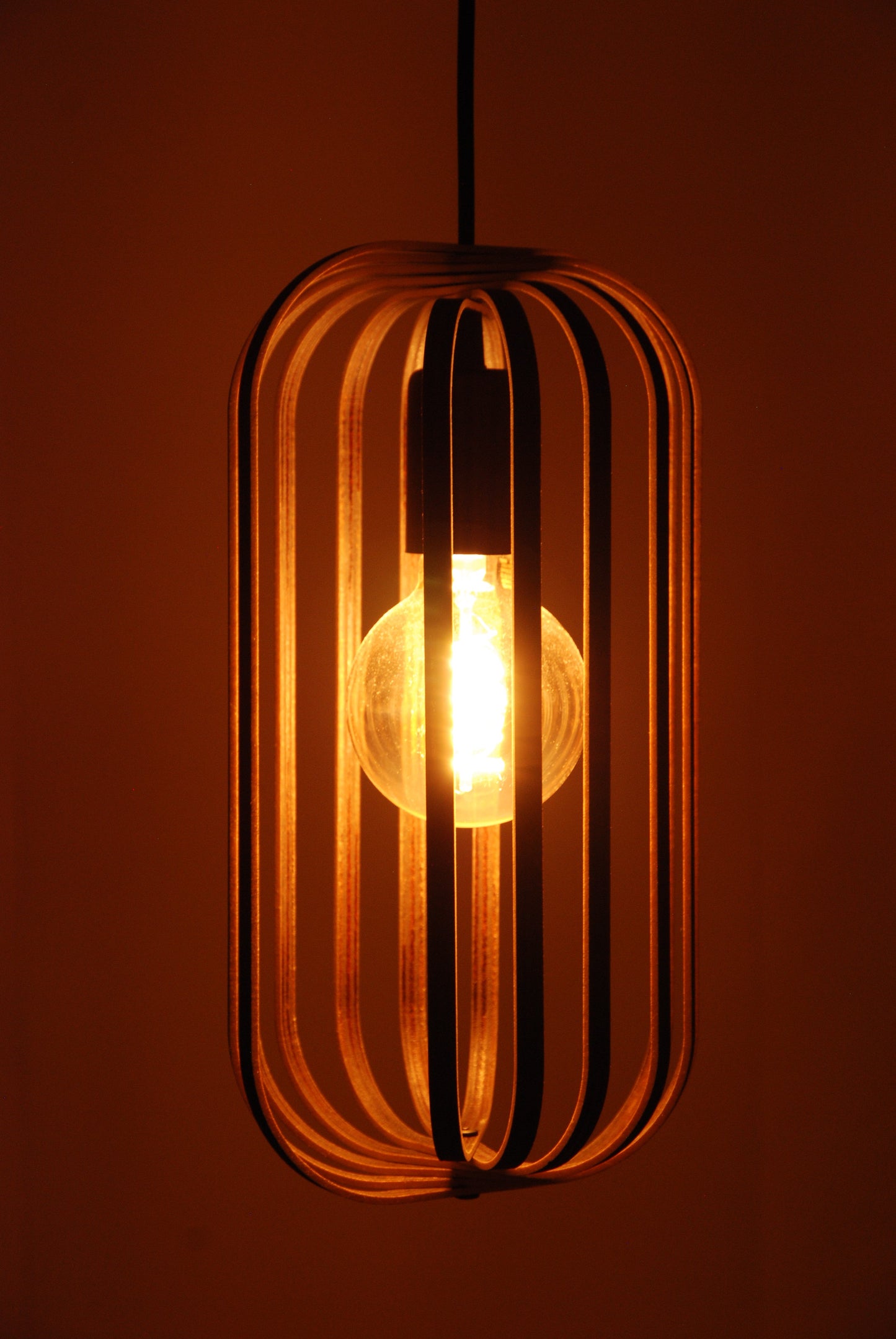 LUWALD NO.04 S Pendelleuchte aus Holz, schwarz, handgefertigt, zylinderförmig, angeschaltet, Ringe, Atmosphäre, Hängelampe,  warm, Seitenansicht, gemütlich