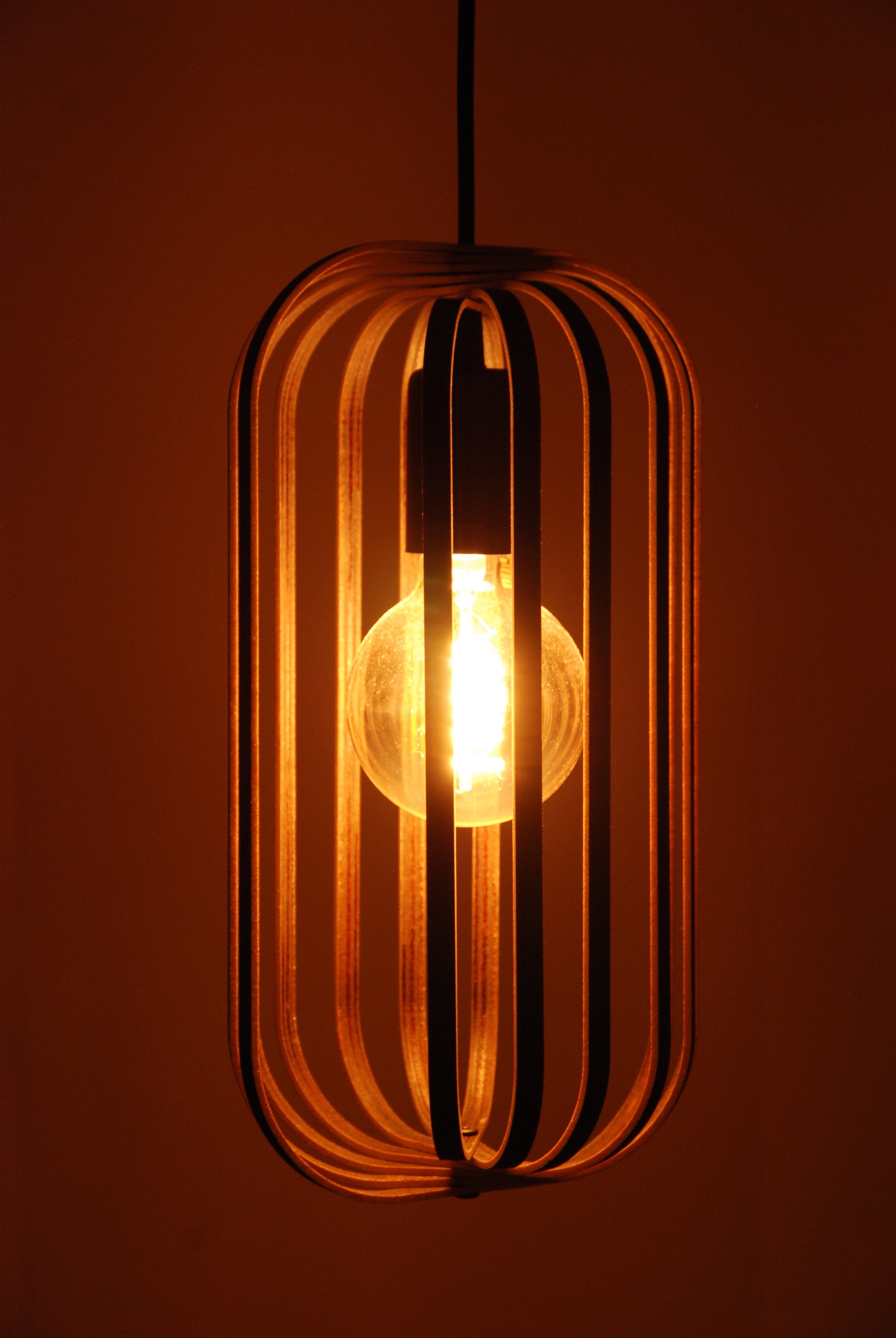 LUWALD NO.04 S Pendelleuchte aus Holz, schwarz, handgefertigt, zylinderförmig, angeschaltet, Ringe, Atmosphäre, Hängelampe,  warm, Seitenansicht, gemütlich