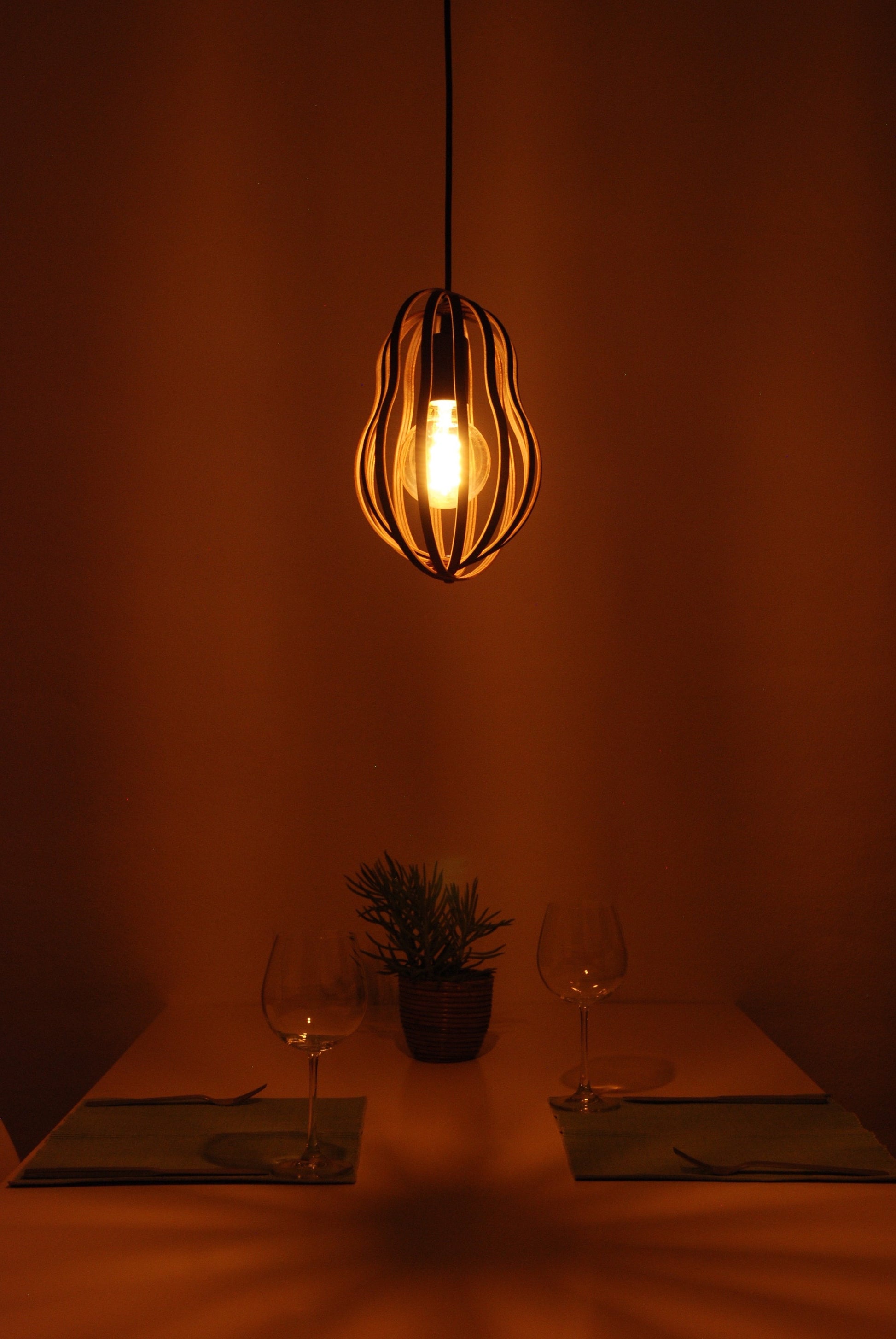 LUWALD NO.02 S, Pendelleuchte aus Holz, schwarz, handgefertigt, birnenförmig, angeschaltet, Tisch, Deko