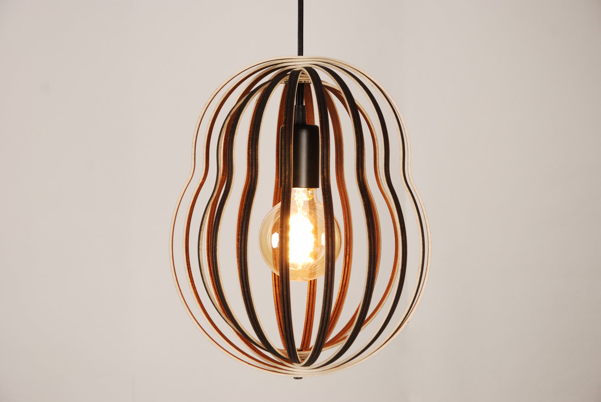 LUWALD NO.02 M Pendelleuchte aus Holz, schwarz, handgefertigt, birnenförmig, angeschaltet, Seitenansicht