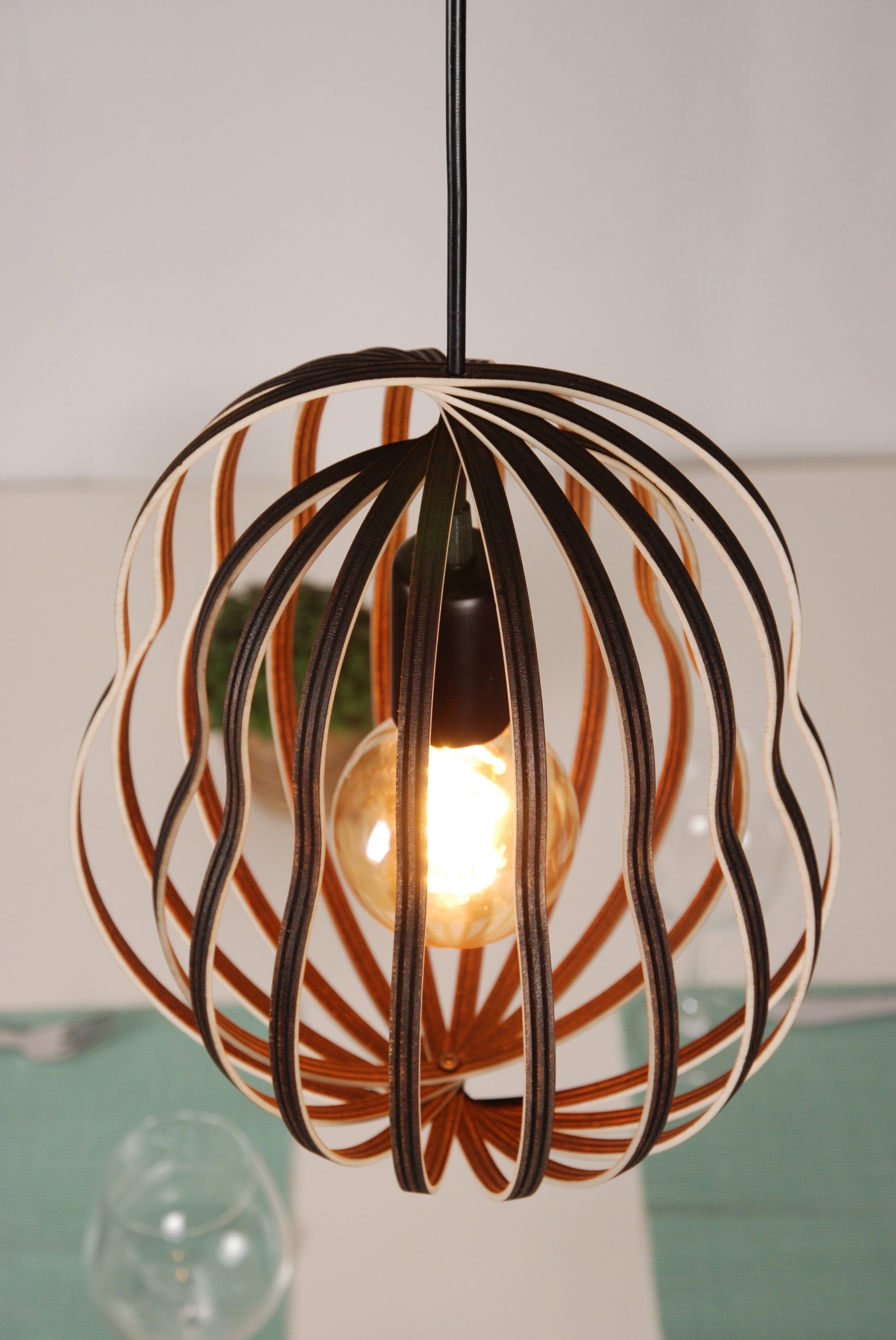 LUWALD NO.02 M Pendelleuchte aus Holz, schwarz, handgefertigt, birnenförmig, angeschaltet, schräg von oben