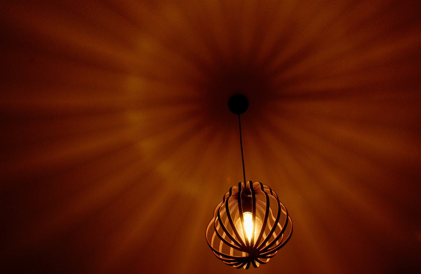 LUWALD NO.02 M Pendelleuchte aus Holz, schwarz, handgefertigt, birnenförmig, angeschaltet, Schatten an Decke