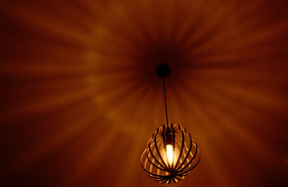 LUWALD NO.02 M Pendelleuchte aus Holz, schwarz, handgefertigt, birnenförmig, angeschaltet, Schatten an Decke