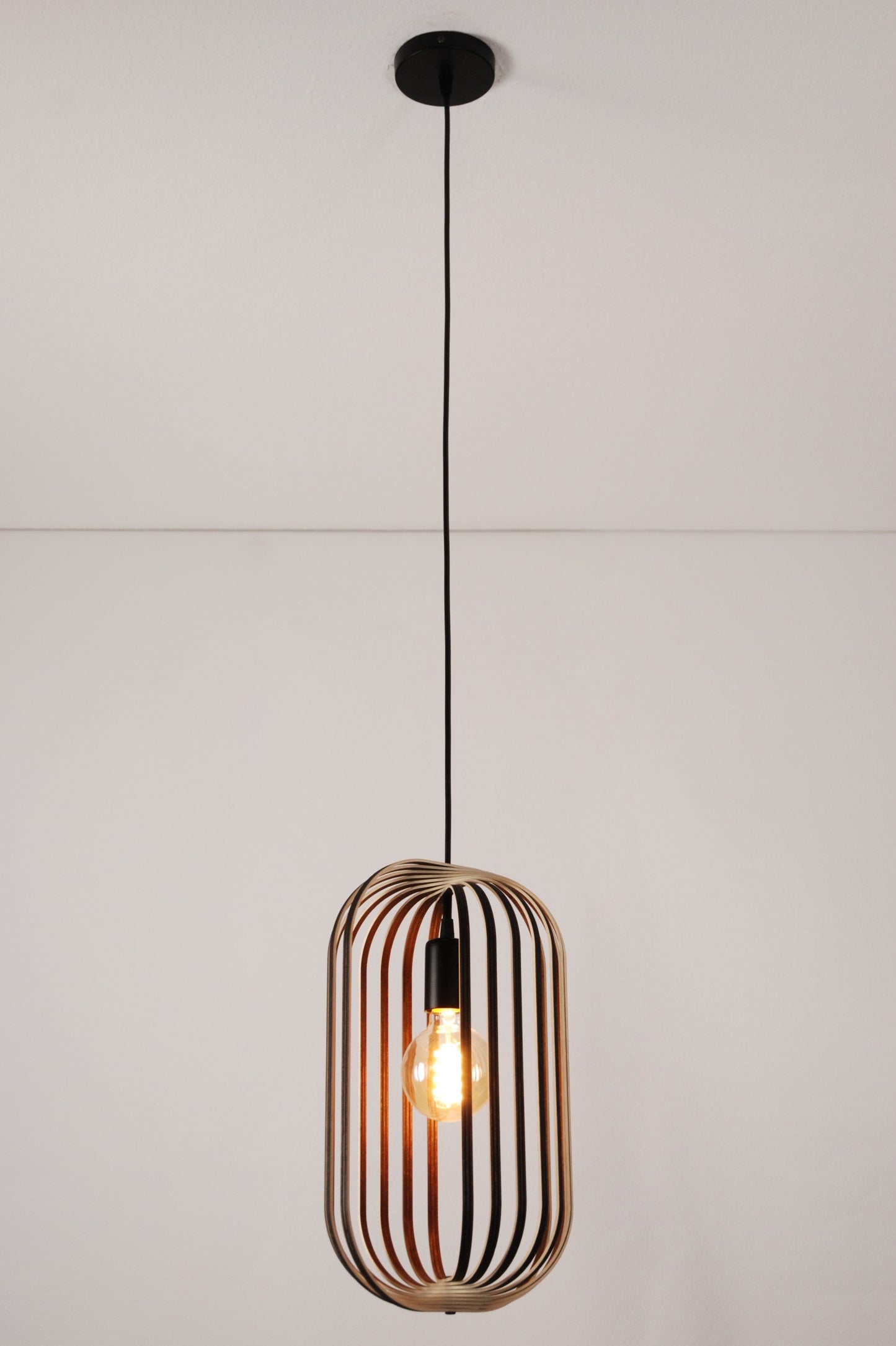 LUWALD NO.04 M Pendelleuchte aus Holz, schwarz, handgefertigt, zylinderförmig, angeschaltet, Ringe, Atmosphäre, Hängelampe,  Gesamtansicht, Deckenmontage