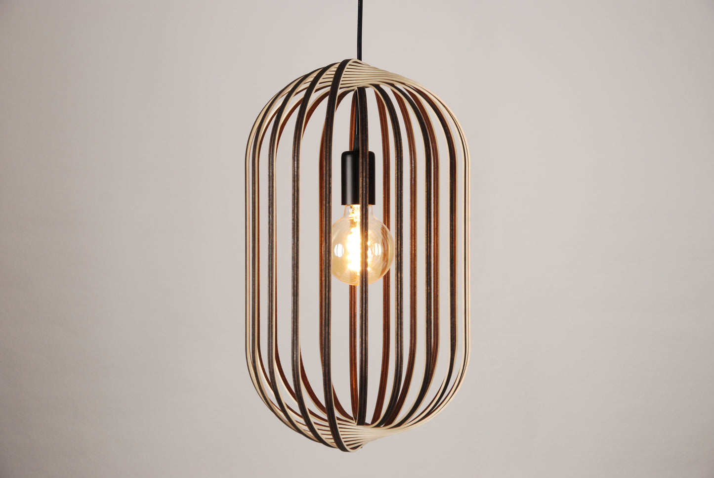 LUWALD NO.04 L Pendelleuchte aus Holz, schwarz, handgefertigt, zylinderförmig, angeschaltet, Ringe, Atmosphäre, Hängelampe, Seitenansicht