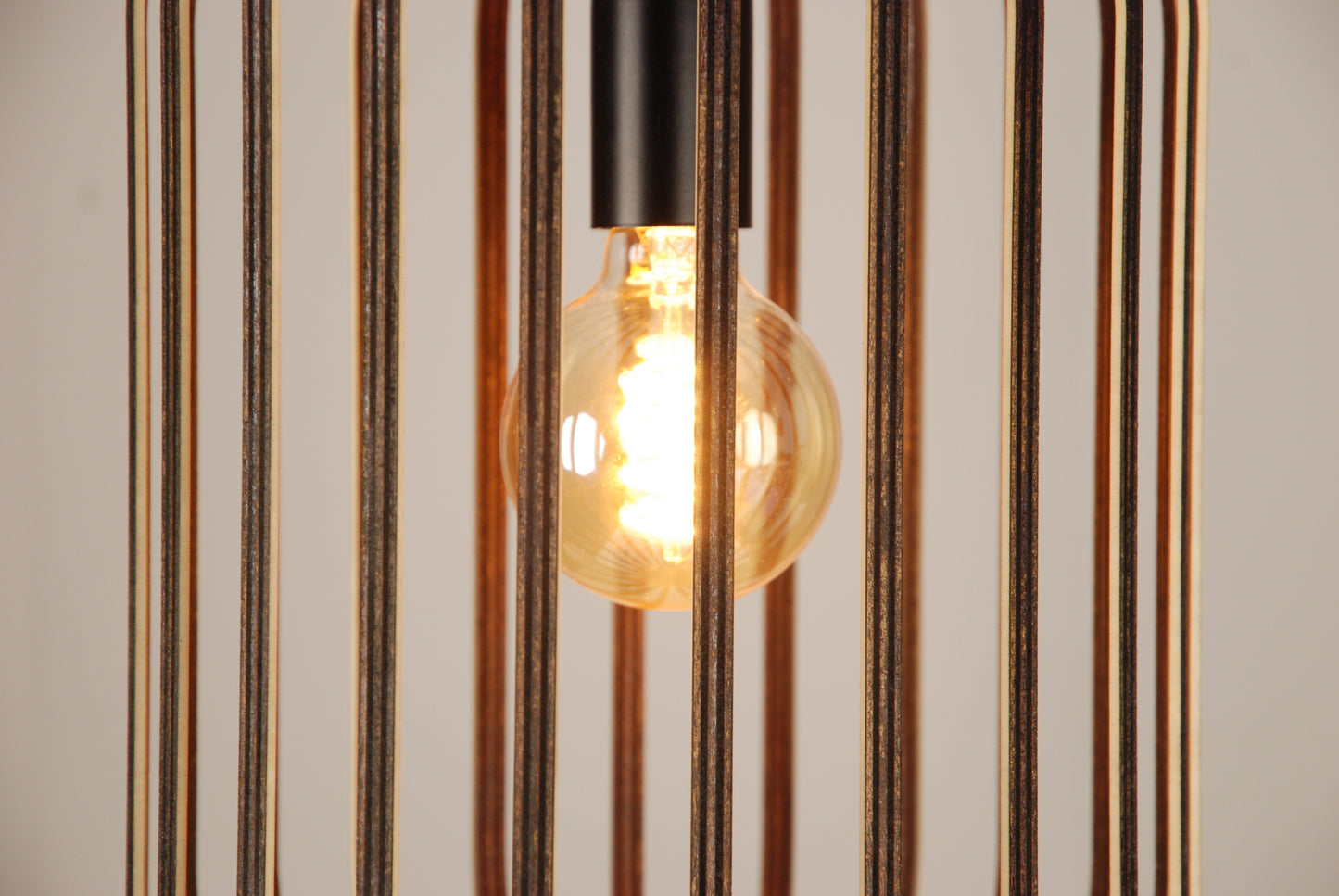 LUWALD NO.04 L Pendelleuchte aus Holz, schwarz, handgefertigt, zylinderförmig, angeschaltet, Ringe, Atmosphäre, Hängelampe, Detail