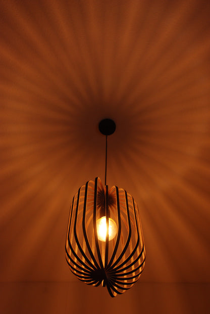 LUWALD NO.04 L Pendelleuchte aus Holz, schwarz, handgefertigt, zylinderförmig, angeschaltet, Ringe, Atmosphäre, Hängelampe, Schatten an Decke, warm