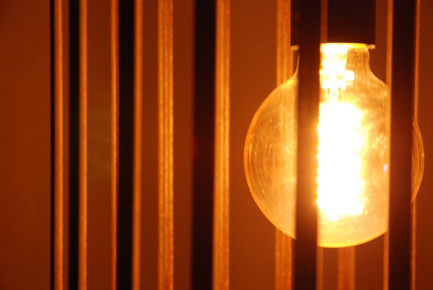 LUWALD NO.04 L Pendelleuchte aus Holz, schwarz, handgefertigt, zylinderförmig, angeschaltet, Ringe, Atmosphäre, Hängelampe, Detail